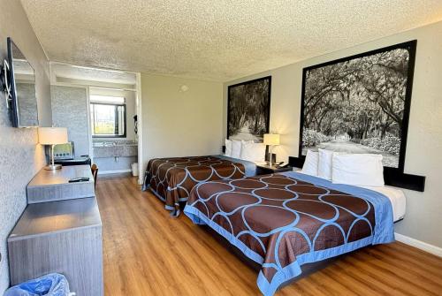 a hotel room with a bed and a large window at Super 8 by Wyndham Hardeeville - Savannah North in Hardeeville