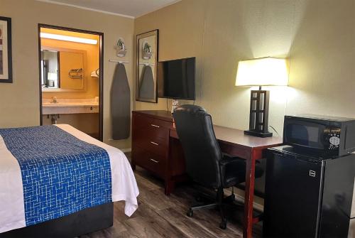 a hotel room with a bed and a desk with a computer at Travelodge by Wyndham Seymour in Seymour