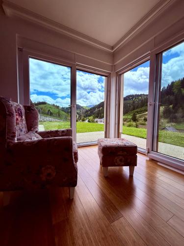a living room with a couch and large windows at Luxury Villa Kadic in Bjelašnica