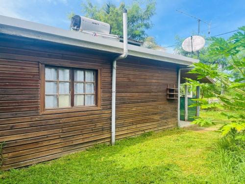 a wooden house with a window on the side of it at By Jess in La Foa
