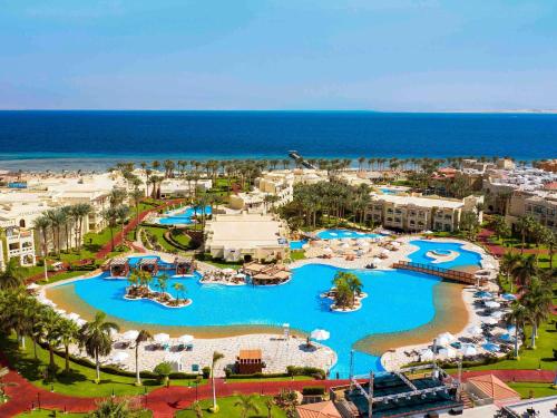 an aerial view of a resort with pools and the ocean at Rixos Sharm El Sheikh - Adults Only 18 Plus in Sharm El Sheikh
