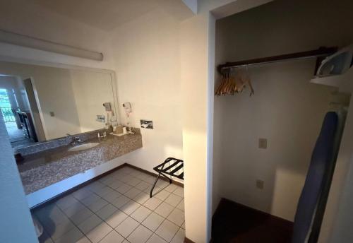 un baño con lavabo y espejo en Days Inn by Wyndham Navasota, en Navasota