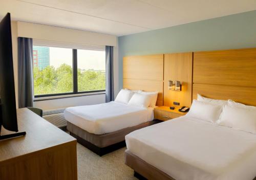 una camera d'albergo con due letti e una finestra di Elimwood Hotel, a Ramada by Wyndham a Maryland Heights