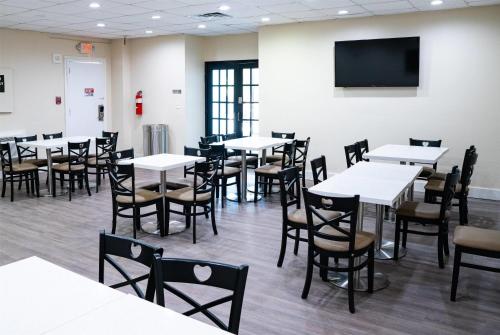 a dining room with tables and chairs and a tv at Super 8 by Wyndham Corpus Christi Airport in Corpus Christi