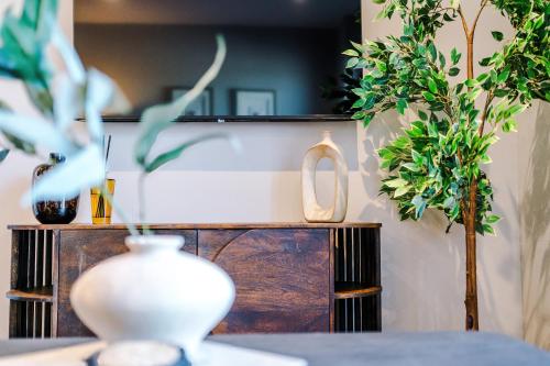 a table with vases and plants on a shelf at Leeds City Centre - HIGH SPEC!! Stunning 2 Bedroom Apartment BRAND NEW!! in Beeston Hill