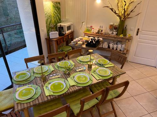 a dining room table with green dishes on it at La Villa Antalya in Ault