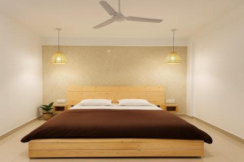 a bedroom with a bed with a ceiling fan at Shelbys Abode in Dehradun