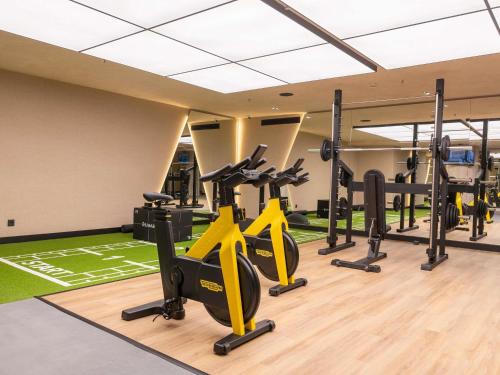 a gym with treadmills and elliptical machines at Novotel Valencia Lavant in Valencia