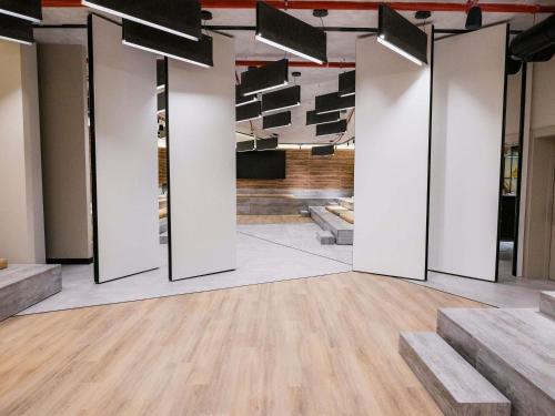 a room with white walls and wooden floors at Novotel Valencia Lavant in Valencia