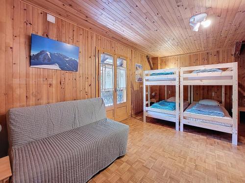 a bedroom with two bunk beds and a couch at APPARTEMENT-3-CHAMBRES-8-COUCHAGES-WIFI-MONTRIOND-CHEBOURINS in Montriond