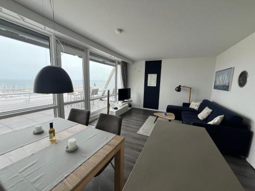 a living room with a couch and a table with a view at Ferienwohnung Fördedeck in Kiel