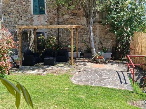 a garden with a pergola and chairs in a yard at Agriturismo Palazzo Vescia in Quercia di Aulla