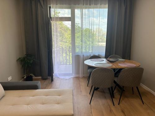Una sala de estar con una mesa y sillas y un sofá. en Guest Apartment Varna,Kabakum, en Varna