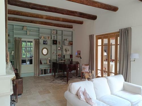 - un salon avec un canapé blanc et un piano dans l'établissement Chara en Provence - Alleins, à Alleins