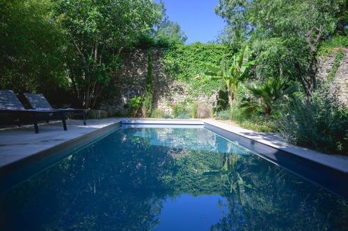 - une piscine avec un banc à côté d'un mur dans l'établissement Chara en Provence - Alleins, à Alleins