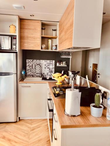 une cuisine avec des appareils électroménagers blancs et des armoires en bois dans l'établissement Mobil home, au Grau-dʼAgde