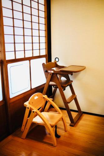 a table and a chair in a room with windows at 1日1組限定 5LDKお洒落古民家 駐車場2台 夜景を望む宿 "一休庵" Traditional house with yard and parking in Hiroshima