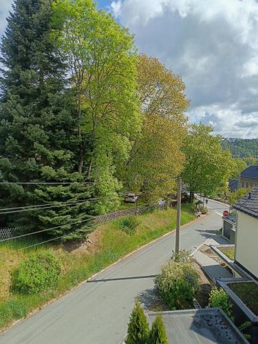 an empty street with trees on the side of a house at Cafe und Pension am Rennsteig in Blankenstein