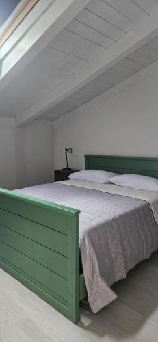 a bedroom with a green bed in a white room at Agriturismo Palazzo Vescia in Quercia di Aulla