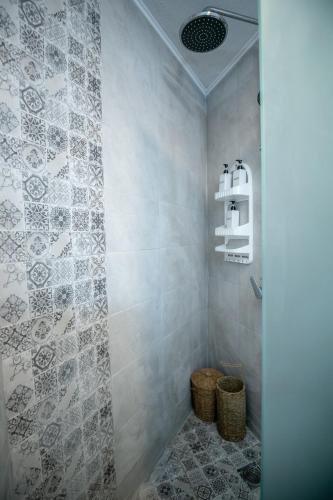 a bathroom with a shower with a tiled wall at Corfu Asonitis Apartment in Ermones