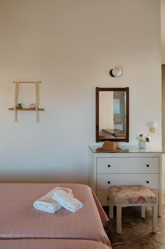 a bedroom with a bed and a dresser with a mirror at Kalamionas Studios & Apartments in Kassiopi
