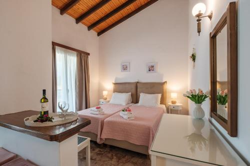 a bedroom with a bed with pink sheets and a window at Kalamionas Studios & Apartments in Kassiopi
