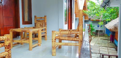 a pair of chairs and a table on a porch at Putri Nyale Bungalows & Rooms in Kuta Lombok