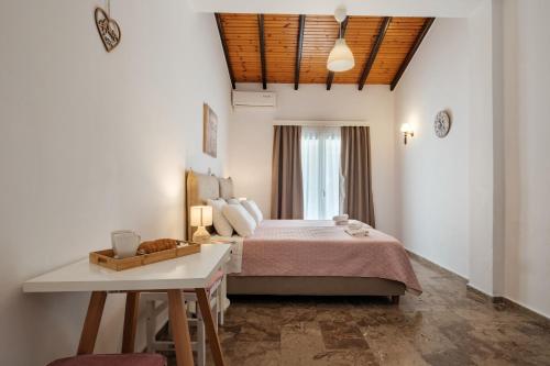 a bedroom with a large bed and a table at Kalamionas Studios & Apartments in Kassiopi
