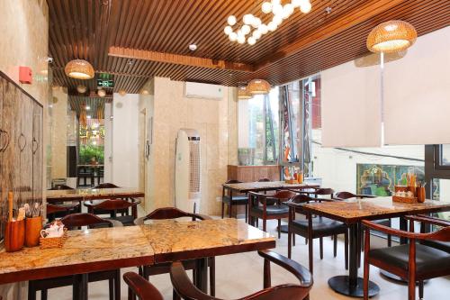 a restaurant with tables and chairs in a room at Azura Gold Hotel & Apartment in Nha Trang