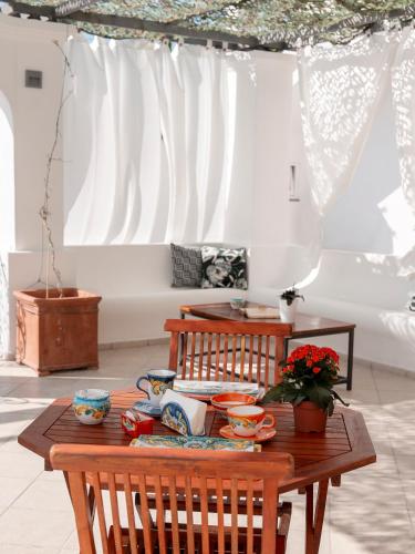 a wooden table with dishes on it in a room at The Sun by alle Stelle b&b in Anacapri