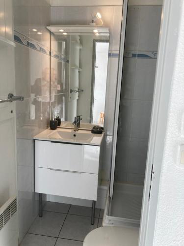 une salle de bain blanche avec un lavabo et une douche dans l'établissement 2 pièces terrasse vue mer Le cap d'Agde, au Cap d'Agde