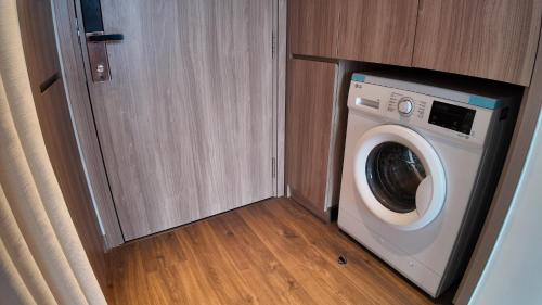 a washing machine in a small room with a door at A La Carte Ha Long Bay Residence by SIMA Chill in Ha Long