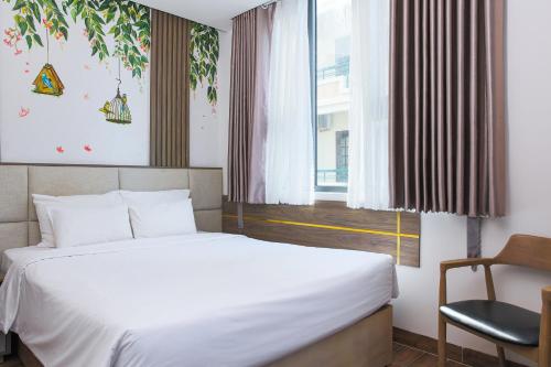 a bedroom with a bed and a chair and a window at Azura Gold Hotel & Apartment in Nha Trang
