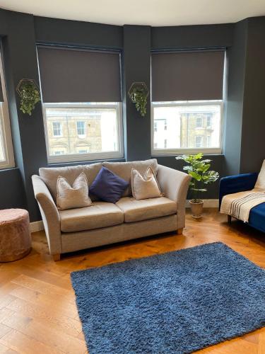 a living room with a couch and two windows at Cosy flat with sea View in Brighton & Hove