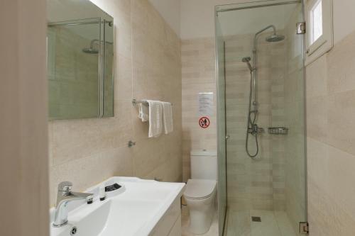 a bathroom with a shower and a sink and a toilet at Kalamionas Studios & Apartments in Kassiopi