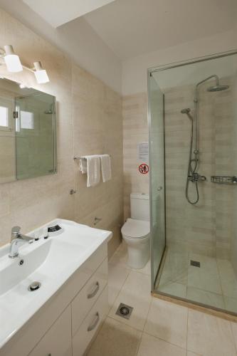 a bathroom with a shower and a sink and a toilet at Kalamionas Studios & Apartments in Kassiopi