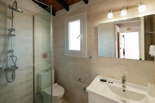 a bathroom with a toilet and a sink and a shower at Kalamionas Studios & Apartments in Kassiopi