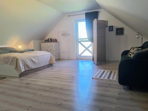 a bedroom with a bed and a large window at Ptasi Zakątek in Tomaryny