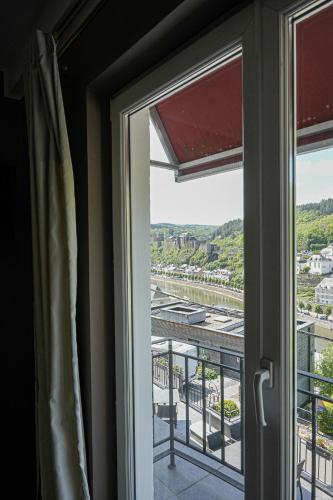 a window with a view of a city at Hôtel Panorama - Vue exceptionnelle sur la Semois in Bouillon