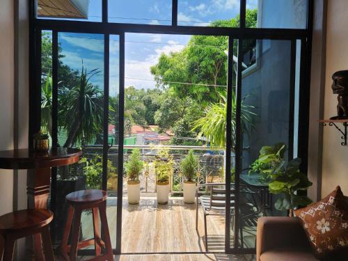 a room with potted plants in pots on a balcony at Goldland Caelestis Guest House in Bacolod