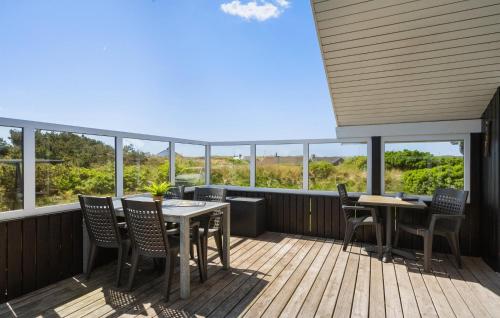 a balcony with tables and chairs and windows at Holiday Home Bjerregårdsvej Hvide Sande in Bjerregård