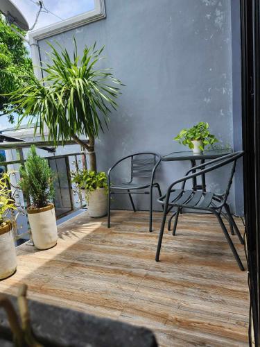 a table and chairs on a balcony with plants at Goldland Caelestis Guest House in Bacolod