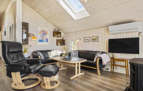 a living room with black leather furniture and a flat screen tv at Holiday Home Bjerregårdsvej Hvide Sande in Bjerregård