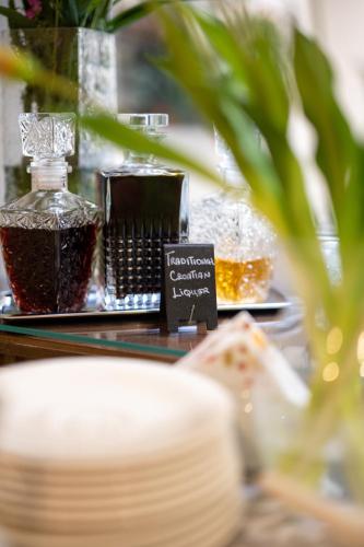 a table with a bottle of perfume and a sign at Heritage Hotel Antique Split in Split