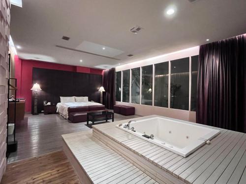 a large room with a bath tub and a bed at Moonlight Motel in Taichung