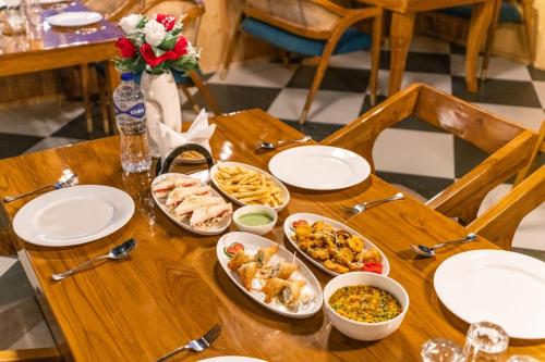 a wooden table with plates of food on it at Ila by Aaryam, Kanatal in Chamba