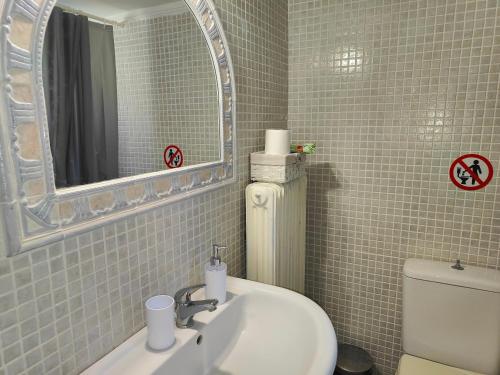 a bathroom with a sink and a mirror and a toilet at Elena's 3BR Maisonette with Garden & Pool in Nea Plagia
