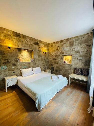 a bedroom with a large bed and two windows at Otel Kallista in Alacati