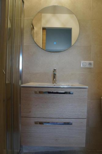 une salle de bain avec un lavabo et un miroir dans l'établissement Le Cabanon des oliviers, à Saint-Hippolyte-le-Graveyron