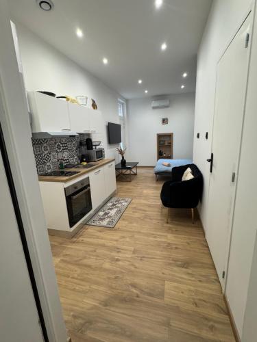 une cuisine avec des placards blancs et une chaise noire dans l'établissement studio entier, à Montauban